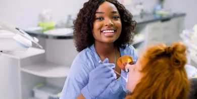 a dental assistant with expanded functions taking x-rays on a patient in a chair after completing a dental assistant training program