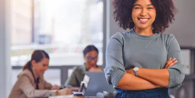 health and human services student standing in a classroom smiling with her arms crossed