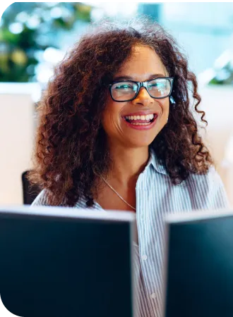 healthcare graduate smiling while looking at computers at her new job