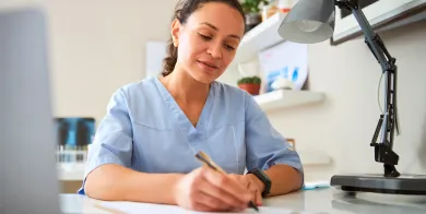 a medical assistant filling out paperwork after completing a medical assistant training program