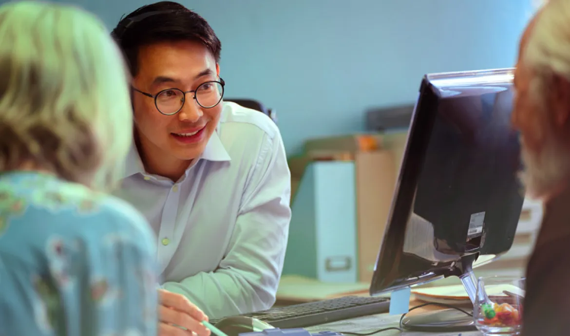 a healthcare office worker explaining paperwork to a patient