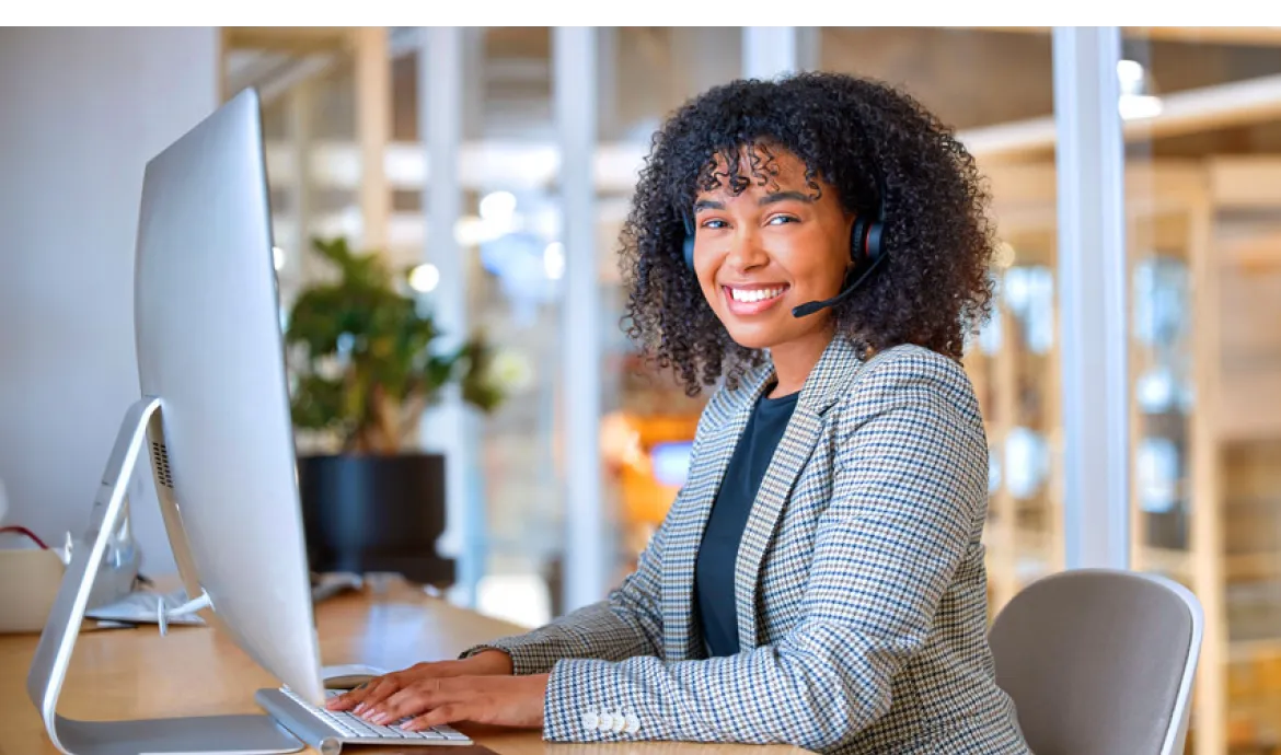 medical billing and coding professional smiling while working on a computer