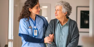 a nursing assistant helping an elderly patient stand