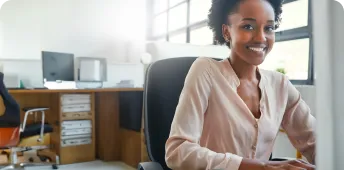 A professional smiles while sitting at a desk