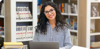 A professional looks on while working at a laptop computer