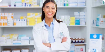 A pharmacy technician smiling in a pharmacy setting