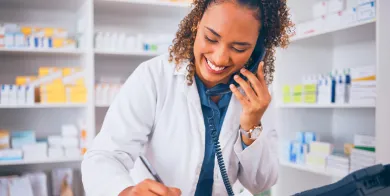 A pharmacy technician explaining prescription drug information to a patient after completing pharmacy technician schooling