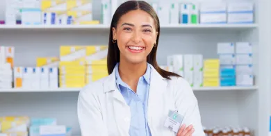 A pharmacy technician with arms crossed smiling