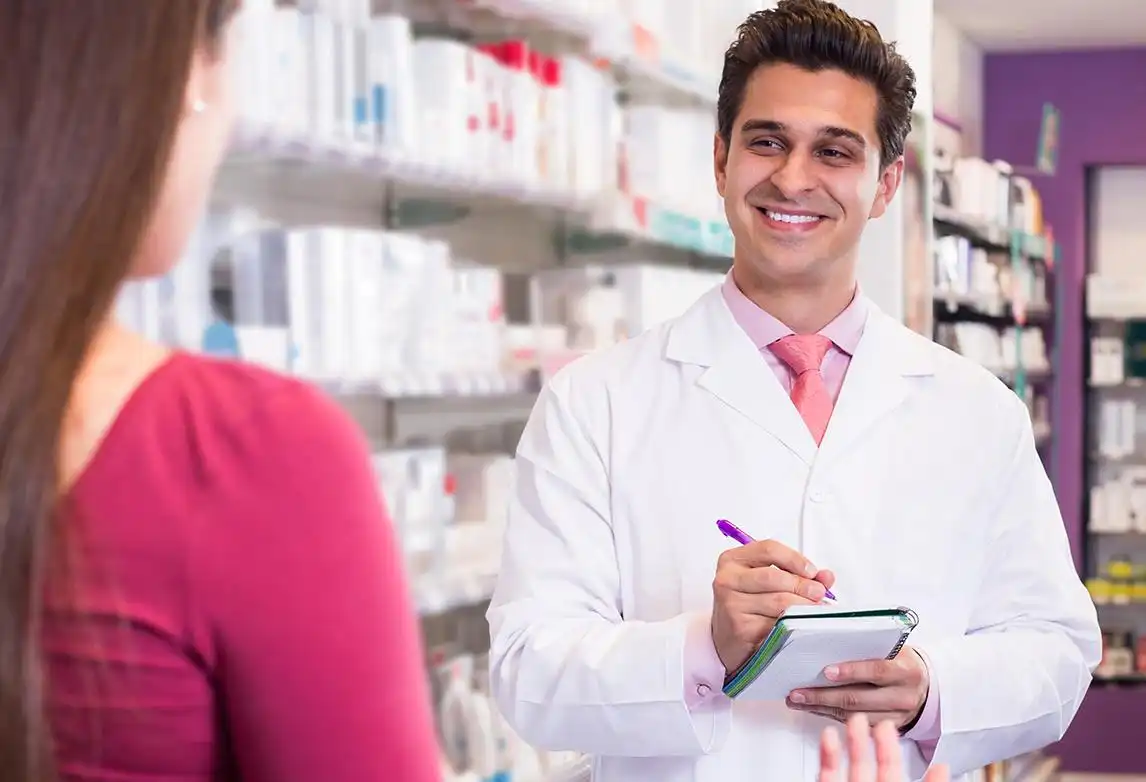 A pharmacy technician interacts with a customer