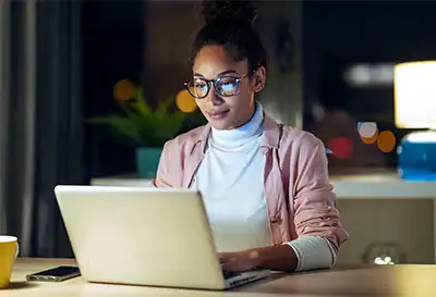 A woman typing on a laptop computer