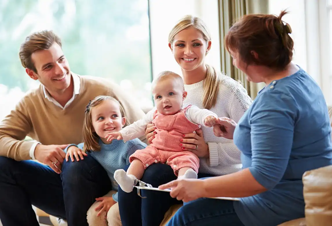 A family with young children meets with a social and human service assistant