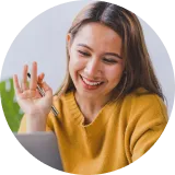 A woman smiling while looking at a computer